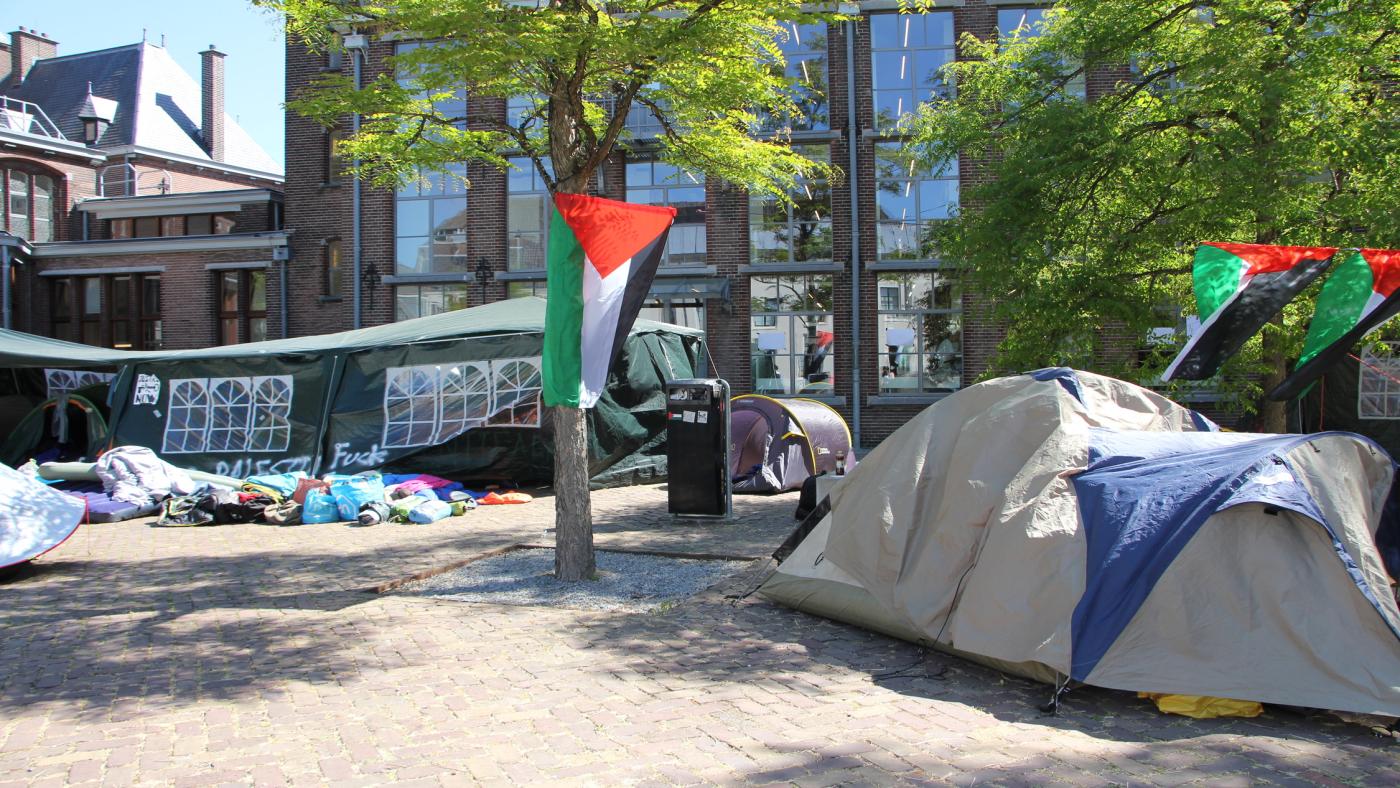 Encampment at the UU City Library. There are many Palestinian flags and tents are visible.