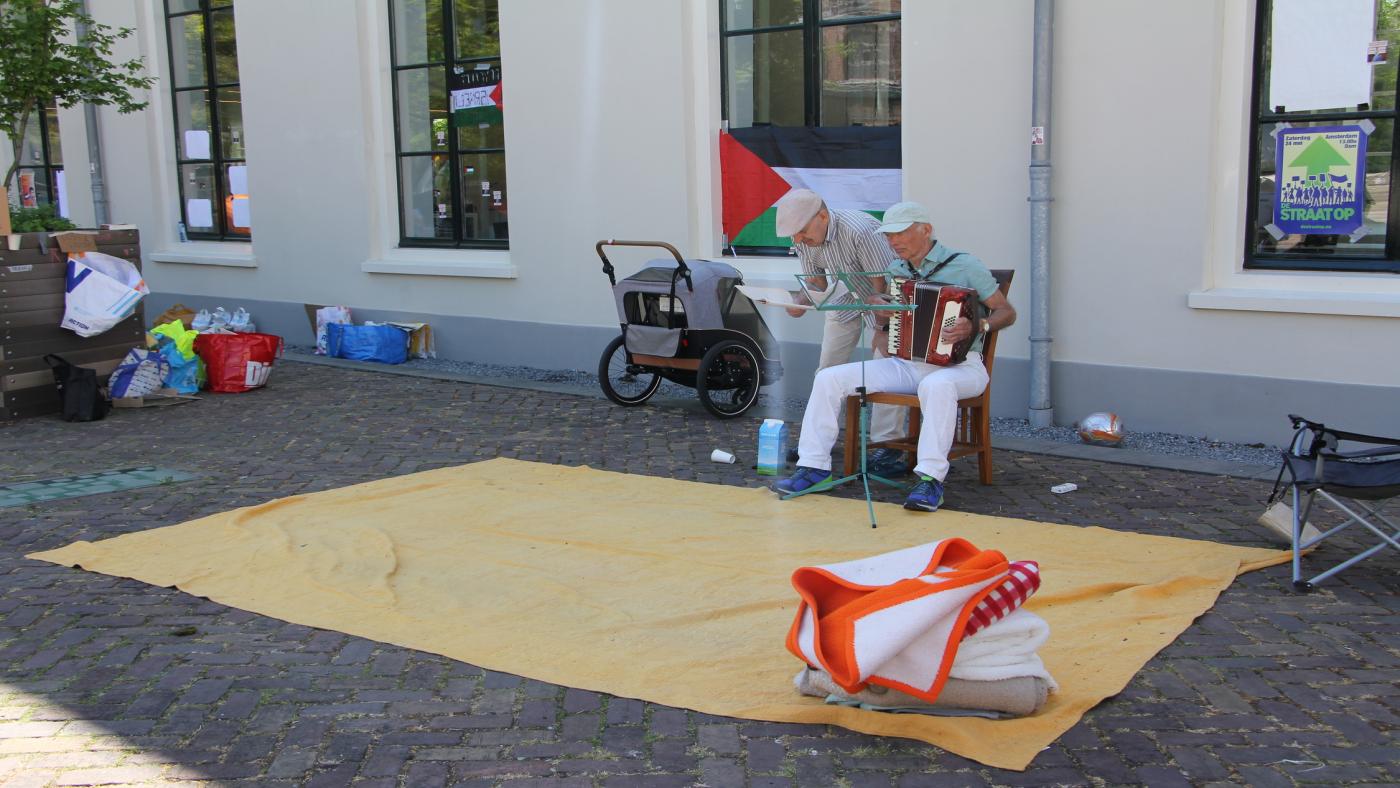 There are two musicians playing an accordion and singing.