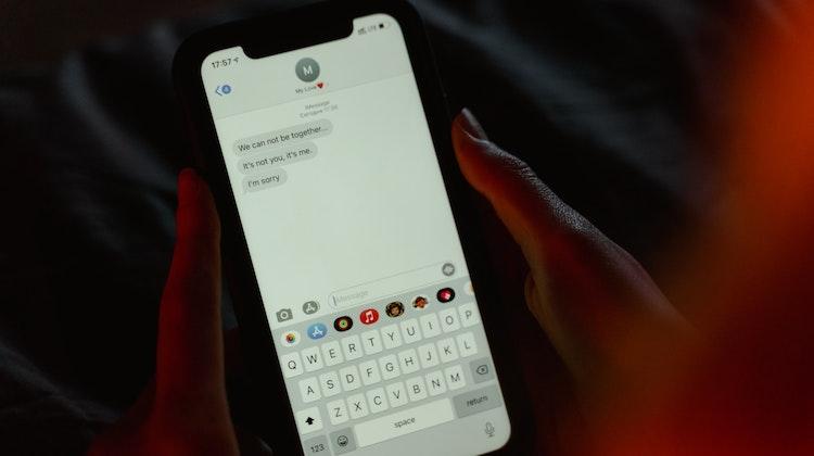 A smartphone showing a few text messages announcing the breakup of a relationship.