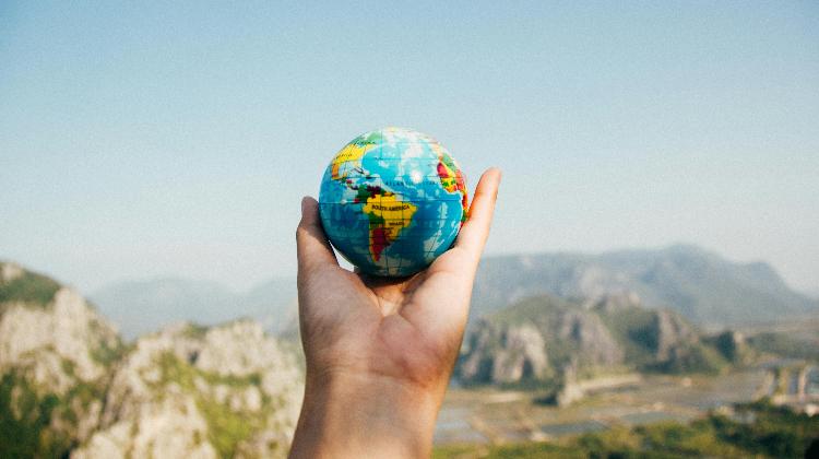 A hand holding a globe