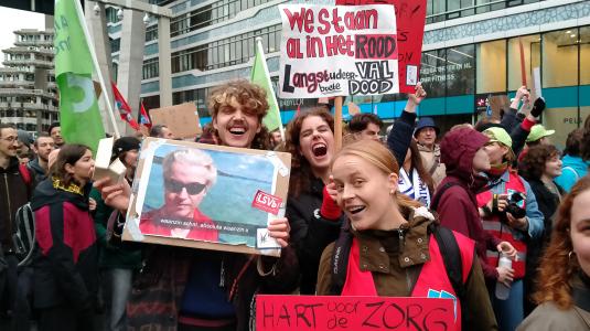 Hermen, Lila en Vera lopen met hun borden in de mars. Foto: Samuel de Weerd